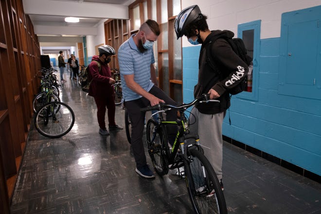 Man helps student with his bicycle