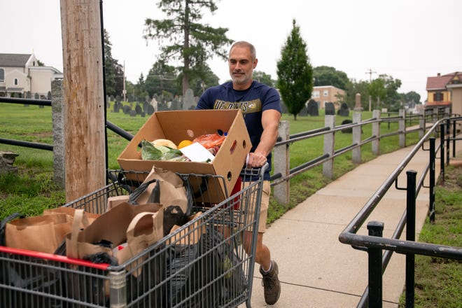 Volunteer Brings carriage filled with groceries to client