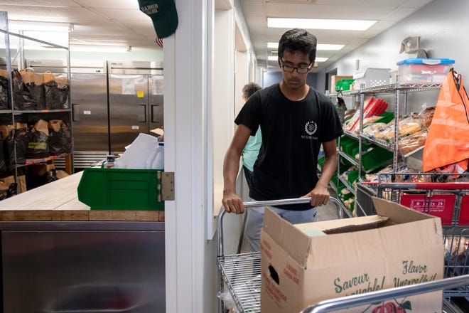 Volunteer helps move boxes at food pantry