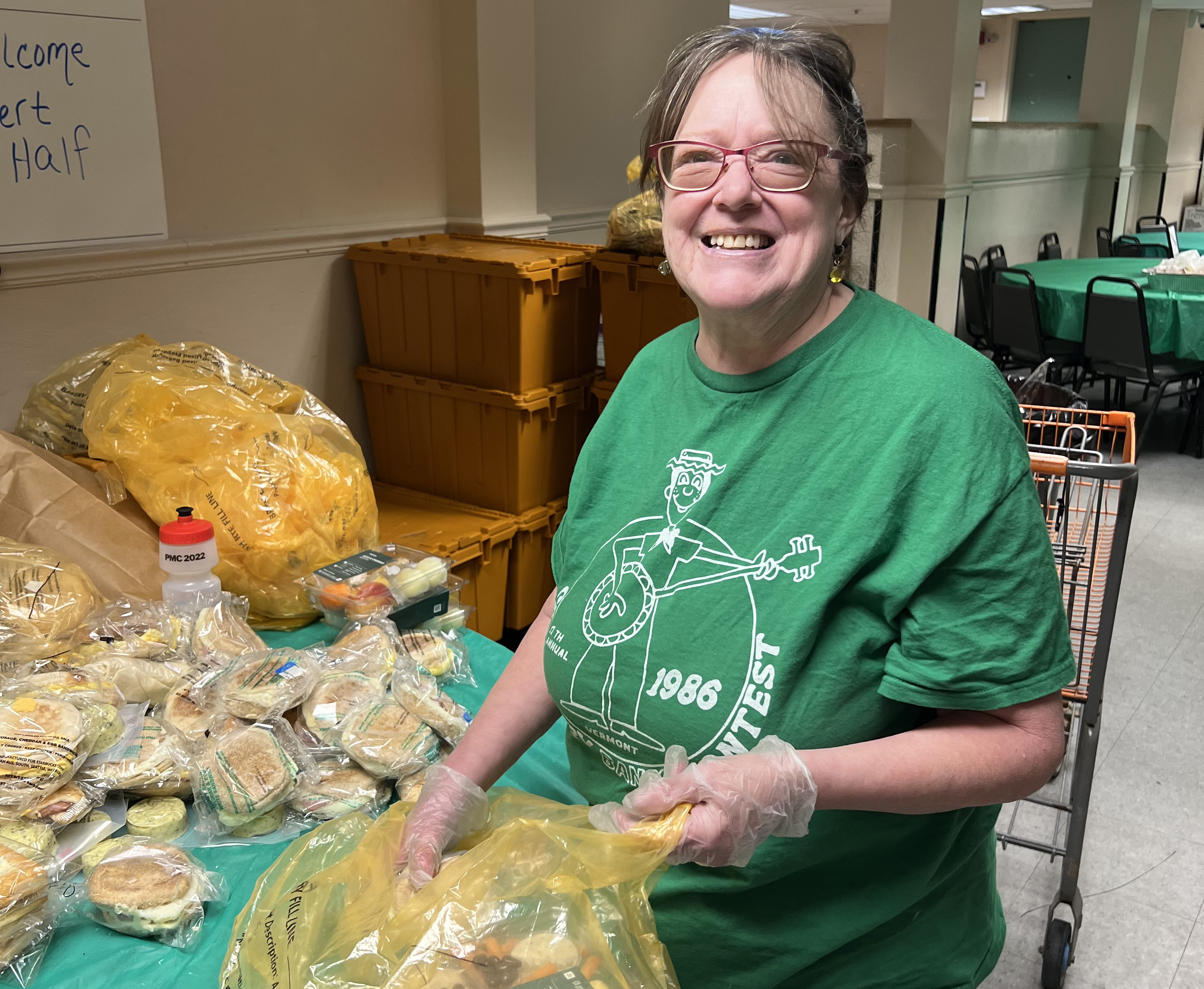 Patrice a volunteer at Pearl Street Cupboard fills bags