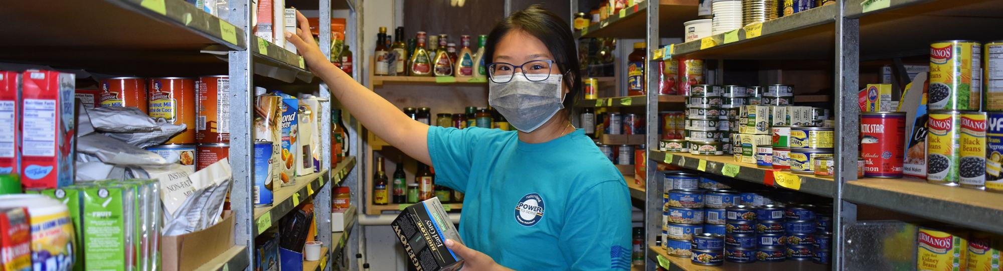Volunteer stocks shelves at Marlborough Community Cupboard