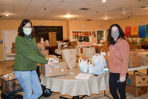 Tow volunteers pack bags for clients