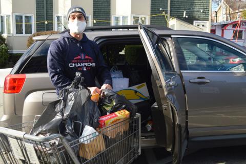 Volunteer puts groceries in client's car